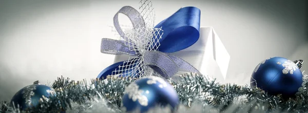 Cadeau de Noël et boules de Noël bleues sur un dos blanc festif — Photo