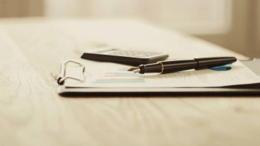 kalem, hesap makinesi ve mali grafik üzerinde bir çalışma alanı