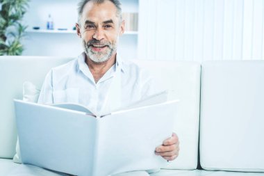 işadamı ile parlak Office kanepede oturan bir dergi.