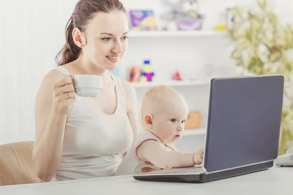 Jonge moeder en baby met behulp van laptop om te communiceren met oma via Skype, — Stockfoto