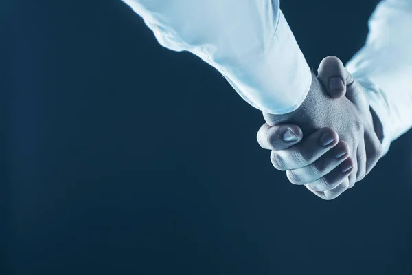 Fogalmának egy megbízható partnerség: kézfogás, üzleti partnerek, a fekete háttér egy részlete. — Stock Fotó