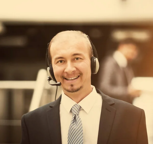 Joven operador de servicio al cliente hablando en los auriculares, sonriendo . — Foto de Stock