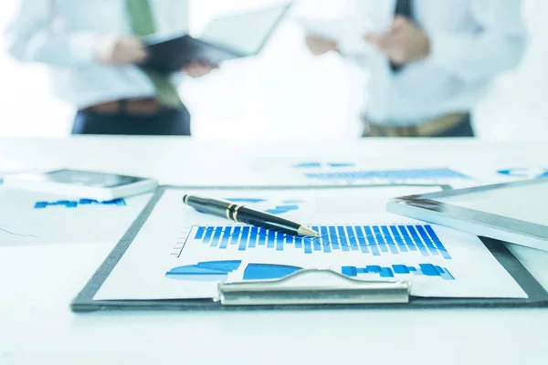 Digital tablet and financial charts on the desktop in the background of the business team — Stock Photo, Image