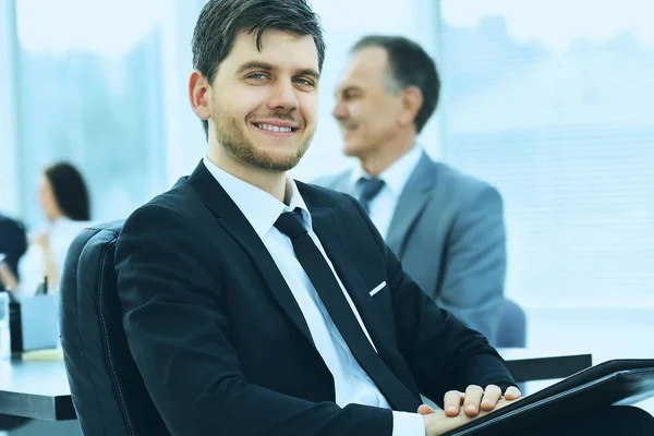 Портрет успешного бизнесмена в офисе на фоне своей команды — стоковое фото