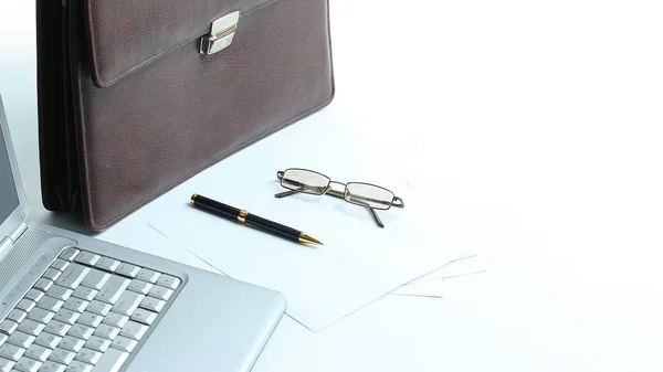 Portátil abierto, maletín y pluma en el escritorio — Foto de Stock