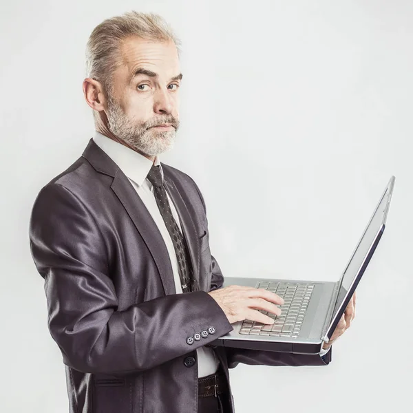 Porträtt i full tillväxt - erfaren affärsman med en öppen laptop på en vit bakgrund — Stockfoto