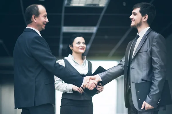 Bilden av en business-team som diskuterar senaste finansiella resultat fastställande affären med ett handslag — Stockfoto