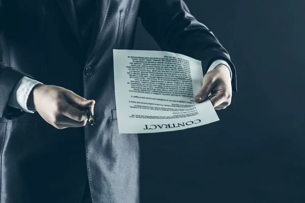 Closeup of a businessman holding a pen and a document with the terms of the contract. — Stock Photo, Image