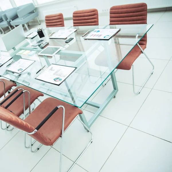 Стол для переговоров с подготовленными финансовыми картами и оргтехникой в конференц-зале перед деловыми встречами . — стоковое фото