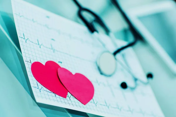Gezondheid concept: twee rode papier hart op het elektrocardiogram, de cardioloog. — Stockfoto