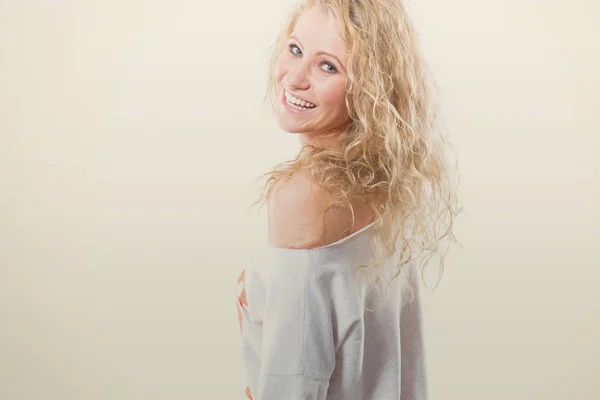 Schöne junge blonde Frau in Weste und Jeans auf weißem Hintergrund — Stockfoto