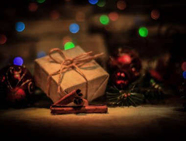 Noel hediyesi ve arka planda Noel ağacı süslemeleri.