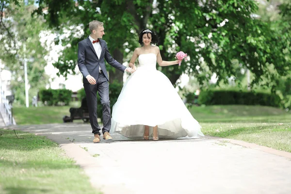 Heureux marié et mariée marcher dans le parc . — Photo