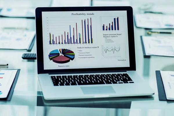 financial graph on the screen of the laptop in the workplace of the financier