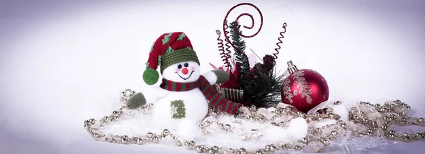 Bonitinho boneco de neve brinquedo e várias decorações de Natal em um b branco — Fotografia de Stock
