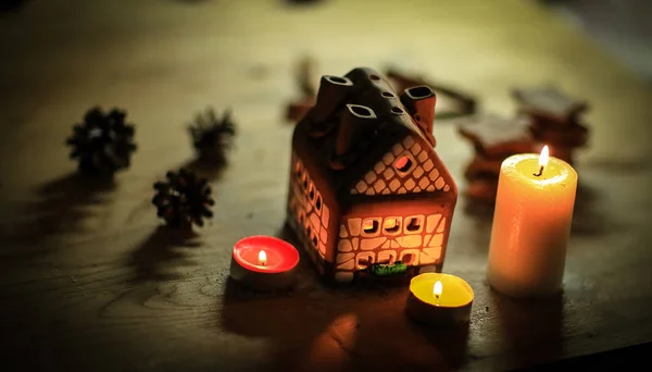 Gingerbread house candle on blurred background of the table. — Stock Photo, Image