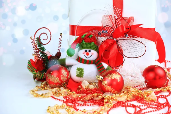 Hristmas gift and snowman on a festive background — Stock Photo, Image