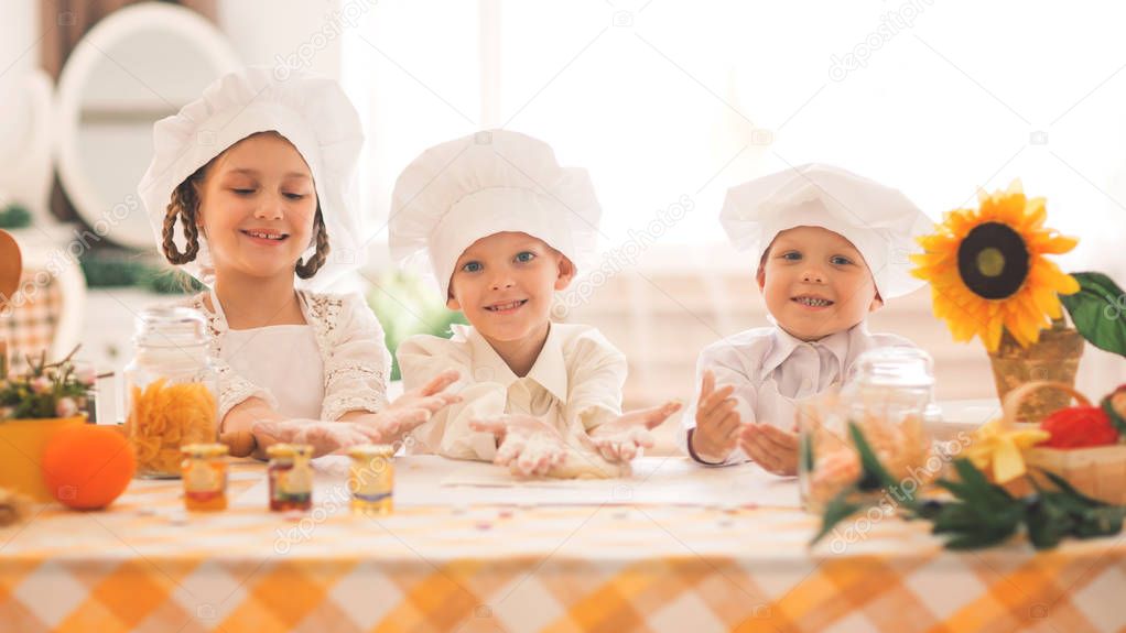 happy little children in the form of a chef to cook a delicious breakfast in the kitchen