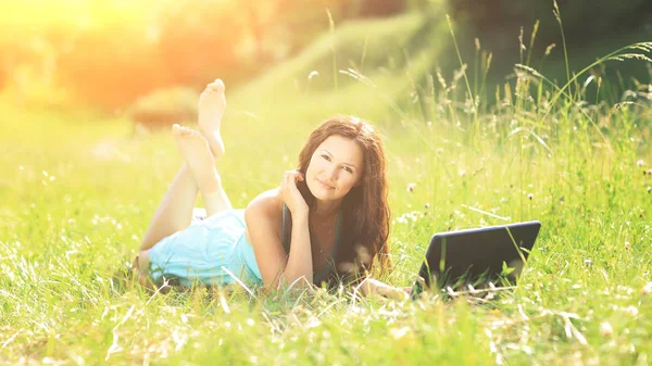 Krásy dívka s notebookem venku v parku za slunečného počasí — Stock fotografie