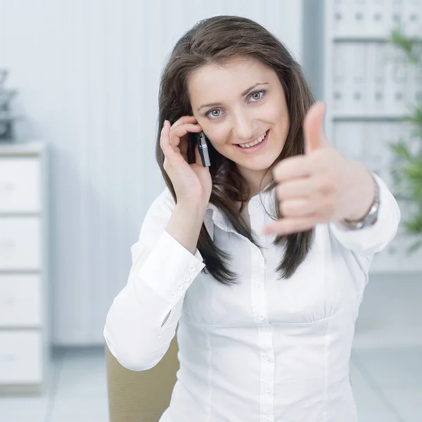 Mujer de negocios exitosa mostrando el pulgar hacia arriba, sentado en su escritorio — Foto de Stock