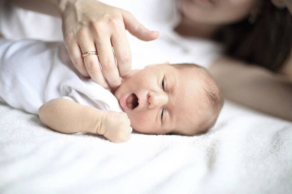 serene newborn baby sleeps next to mom