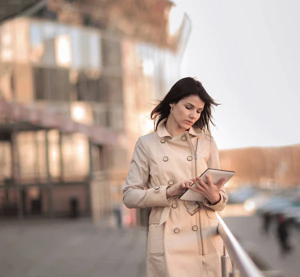 Zakenvrouw met een digitaal tablet op de achtergrond van een moderne kantoorgebouw — Stockfoto