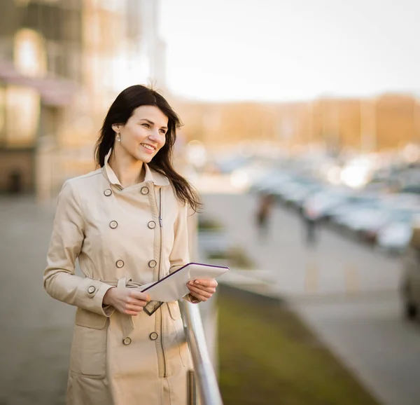 Mulher de negócios moderna trabalhando em um tablet digital, ao lado de um prédio de escritórios — Fotografia de Stock