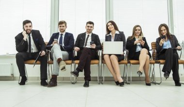 iş takım smartphone ve modern ofis lobisinde otururken dizüstü bilgisayar ile