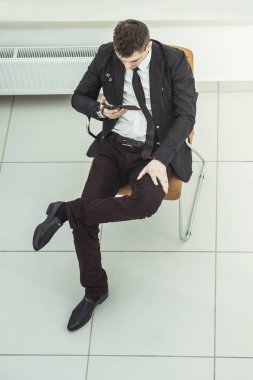 ile bir ofis koltuğu oturan smartphone başarılı iş adamı
