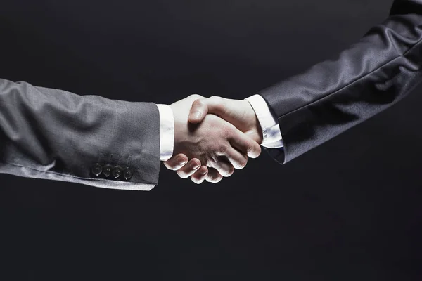 Närbild. Handshake business partners.isolated på svart bakgrund — Stockfoto