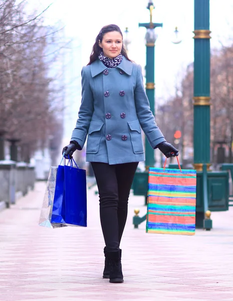 Alışveriş torbaları şehir sokakta yürüyen genç kadınla — Stok fotoğraf