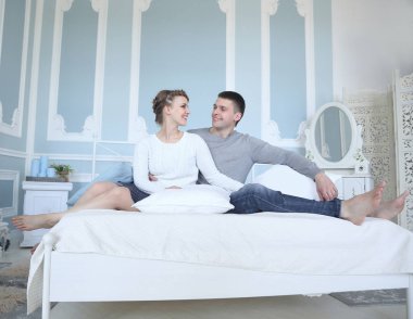 Genç, gülümseyen romantik çift birbirinin yanında rahatlıyor..