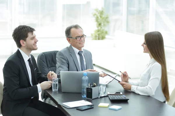Manager werk kwesties bespreken met zijn assistenten achter een bureau — Stockfoto