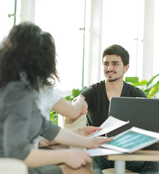 Colleghi di stretta di mano seduti sul posto di lavoro . — Foto Stock