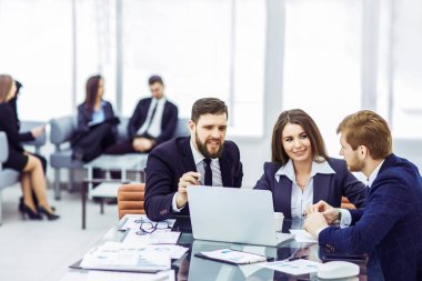 şirket çalışanlarının iş üstünde laptop ile şirketin gelişimi hakkında bilgi