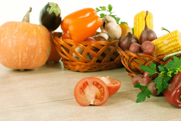 Fresh vegetables in wicker baskets on the wooden table. — Stock Photo, Image