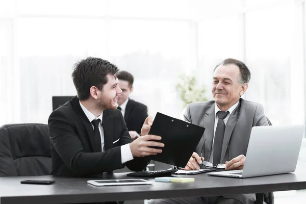 Jefe y empleado discutiendo el documento sentado en el escritorio en la oficina . — Foto de Stock