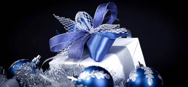Closeup. Χριστουγεννιάτικο δώρο και μπλε μπάλες Χριστουγέννων σε μια εορταστική w — Φωτογραφία Αρχείου