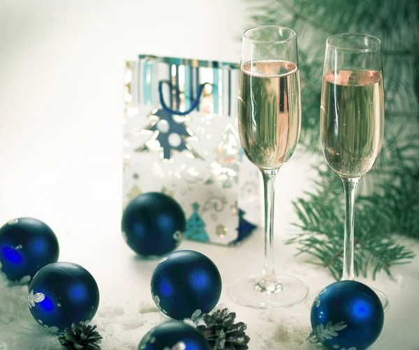 Due bicchieri con champagne e regalo sullo sfondo di Natale — Foto Stock