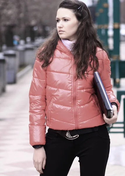 Ung kvinna student med laptop på bakgrunden av en Vinterstaden — Stockfoto