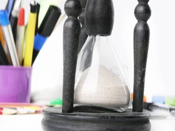 Close up.hourglass on blurred background of office supplies Stock Image