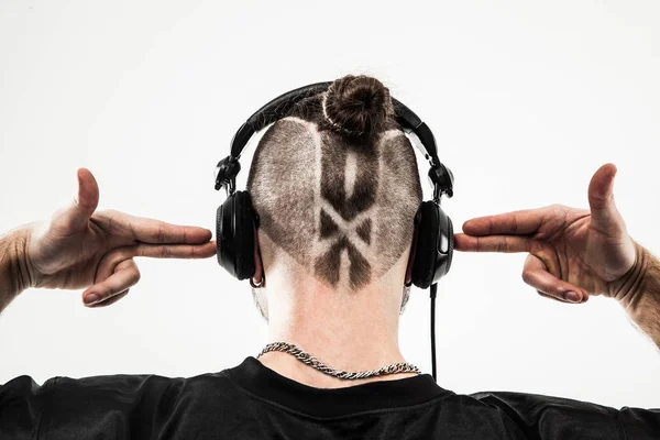 Visão traseira - os fones de ouvido de rapper com um penteado elegante e uma tatuagem — Fotografia de Stock