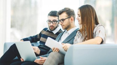  çalışanların ofis lobisinde oturan bir dizüstü bilgisayar ile