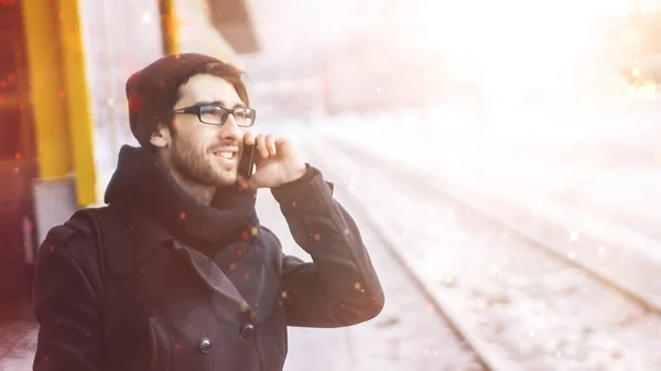 Giovane uomo elegante con uno smartphone in piedi in una stazione della metropolitana — Foto Stock