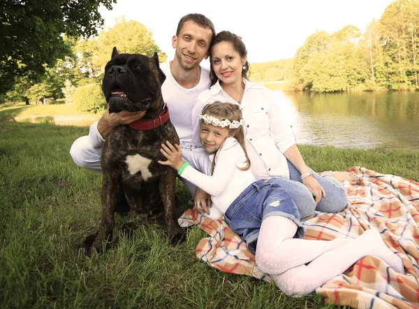 Gelukkige familie met huisdier hond bij de picknick in een zonnige zomerdag. pregn — Stockfoto