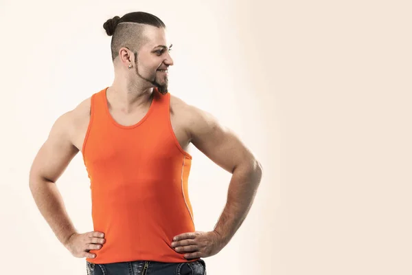 Portret sportowy facet - kulturysta w dżinsy i t-shirt pomarańczowy — Zdjęcie stockowe