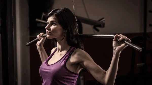 Geschäftsfrau beim Training an einem Fitnessgerät in einem Fitnessclub. — Stockfoto