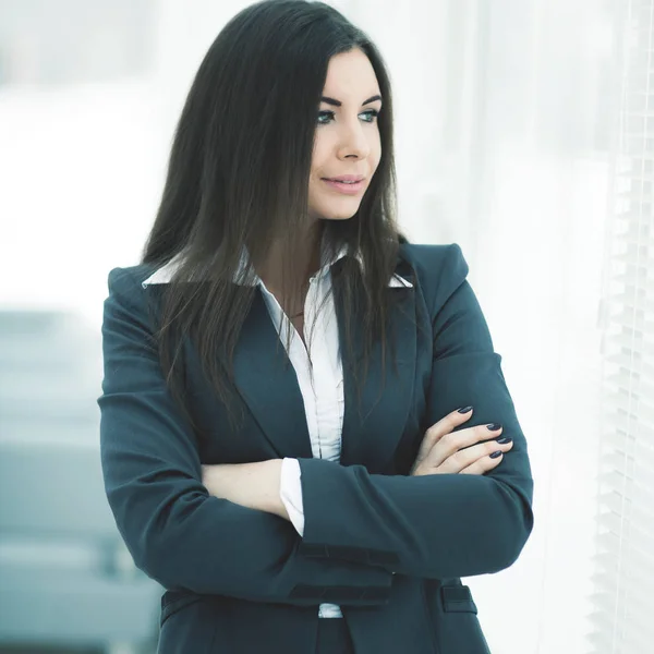 Successful business woman standing near window with hands claspe — Stock Photo, Image