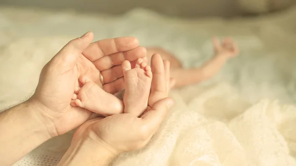 .happy mother hugging the legs of a newborn baby. — Stock Photo, Image