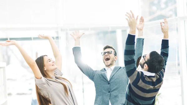 Концепция победы - ликующая деловая команда, стоящая в кругу, руки вверх в радости успеха . Стоковое Фото